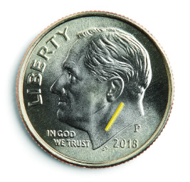 A close-up view of a dime showing how small the yutiq implant's size is